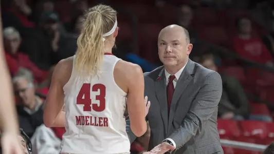 Head coach Jonathan Tsipis slaps the hands of Grace Mueller on the sidelines.