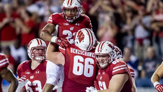 Beau Benzschawel lifts Jonathan Taylor in celebration with Michael Deiter in football game vs. Western Kentucky 2018