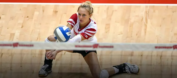 Kelli Bates goes down on one knee to pass the ball.