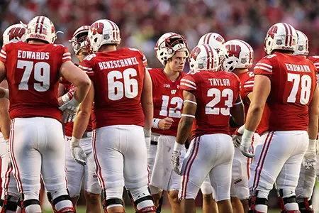Alex Hornibrook and foootball team huddle vs. Purdue 2017
