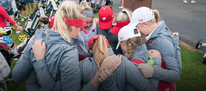 The women's golf team huddles before starting round 1 of the 2017 East-West Match Play at University Ridge Golf Course