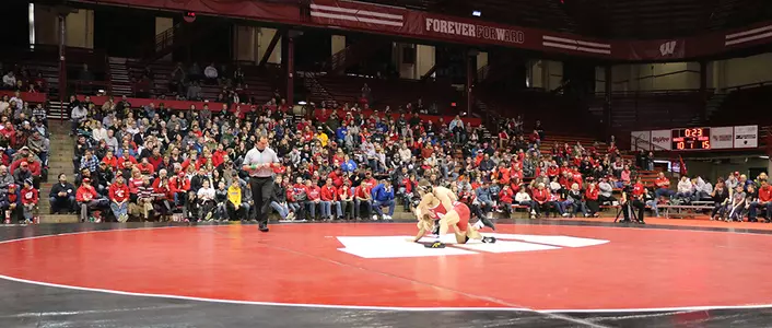 two wrestlers grapple in a wrestling match at UW Field House