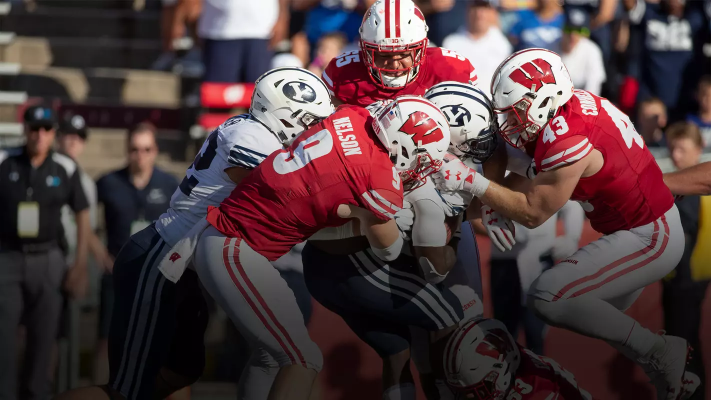 Wisconsin football defense Scott Nelson and teammates tackle BYU player during game at Camp Randall Stadium 2018