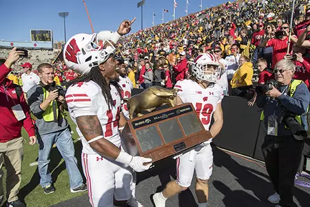 Wisconsin Badgers teammates D'Cota Dixon (14) and Leo Musso (19) carry the Heartland Trophy back to the locker room after an NCAA Big Ten Conference college football game against the Iowa Hawkeyes Saturday, October 22, 2016, in Iowa City, Iowa. The Badgers won 17-9. (Photo by David Stluka)
