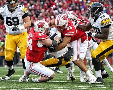 Conor Sheehy and T.J. Edwards tackle an Iowa player in football game at Camp Randall Stadium 2017