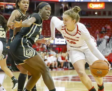 Kendra Van Leeuwen dribbles past a Purdue defender.