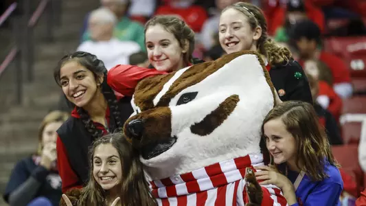 Fans pose with Bucky Badger at a game.