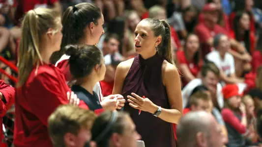 Brittany Dildine talks to players on the bench.