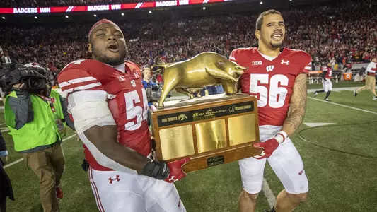 Chris Orr and Zack Baun hold the Heartland Trophy - vs. Iowa 2019