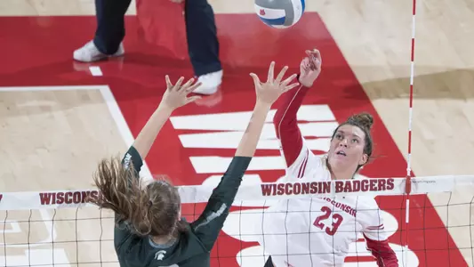 Molly Haggerty hits the ball against a Michigan State blocker.