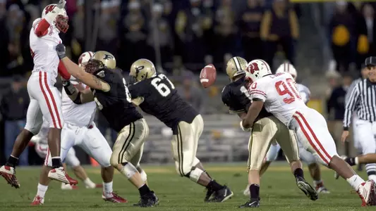 Defensive lineman Erasmus James #90 of the Wisconsin Badgers sacks quarterback Kyle Orton #18 of the Purdue Boilermakers and forces a turnover at Ross-Ade Stadium in West Lafayette, Indiana on October 16, 2004. Wisconsin beat Purdue 20-17. (Photo by David Stluka)