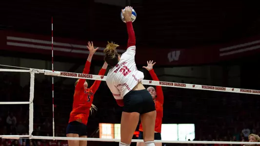 Grace Loberg hits against two Illinois blockers.