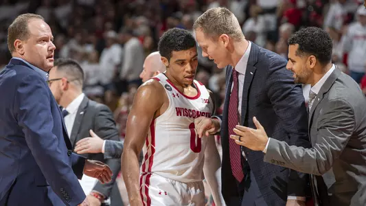 Wisconsin Badgers Guard D'Mitrik Trice (0) talks to coaches Joe Krabbenhoft and Dean Oliver during an NCAA college basketball game against the Marquette Golden Eagles Sunday, Nov. 17, 2019, in Madison, Wis. The Badgers won 77-61. (Photo by David Stluka/Wisconsin Athletic Communications)