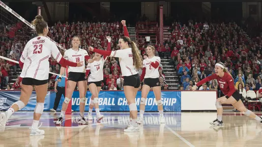 The Badgers celebrate on the court during a match.