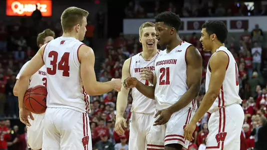 Khalil Iverson, Brad Davison, Brevin Pritzl and D'Mitrik Trice high five during a game against Illinois at the Kohl Center 2019