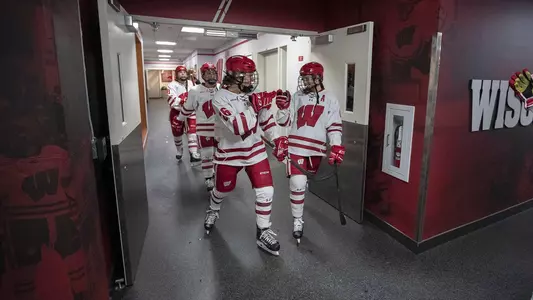 Emily Clark and Maddie Rolfes give each other a fist bump heading out of the locker room at women's hockey vs. Syracuse at LaBahna Arena December 2, 2018