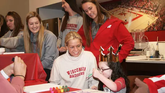 Badgers Give Back - Volleyball freshman Riley Bell paints a canvas with five-year-old Izzy.