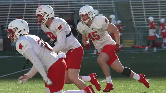 Leo Chenal (45) and Tyler Johnson (59) run with teammates at spring practice inside Camp Randall Stadium 2019