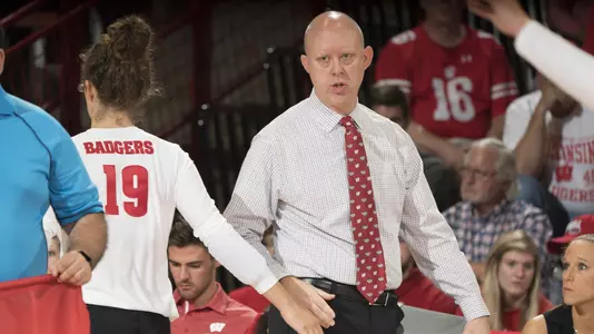 Head coach Kelly Sheffield slaps hands with M.E. Dodge ont he sidelines.