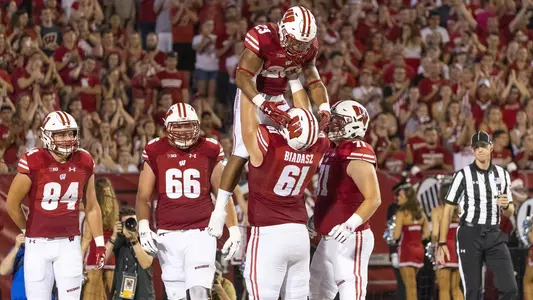 Tyler Biadasz lifts teammate Jonathan Taylor to celebrate a touchdown against the Western Kentucky Hilltoppers Friday, August 31, 2018, in Madison, Wisconsin. The Badgers won 34-3. (Photo by David Stluka)