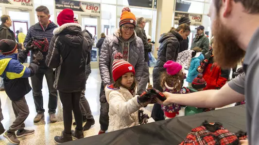 Young fan receives a hat at women's basketball Sunday Kids Day event
