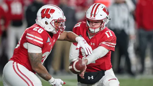 Jack Coan hands the ball of to running back Taiwan Deal