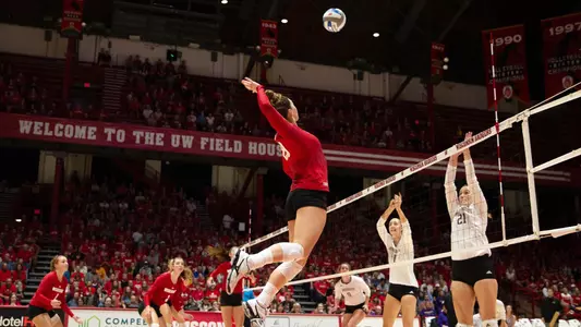 Molly Haggerty hits the ball against two Washington blockers.