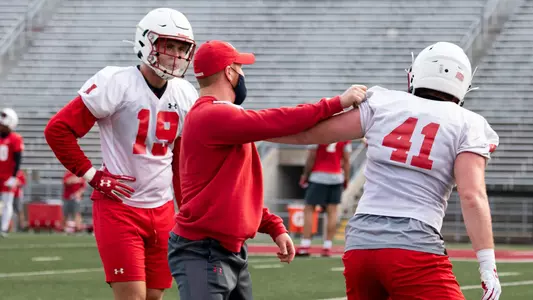 OLB Nick Herbig (19) with outside linebackers coach Bobby April and OLB Noah Burks (41)