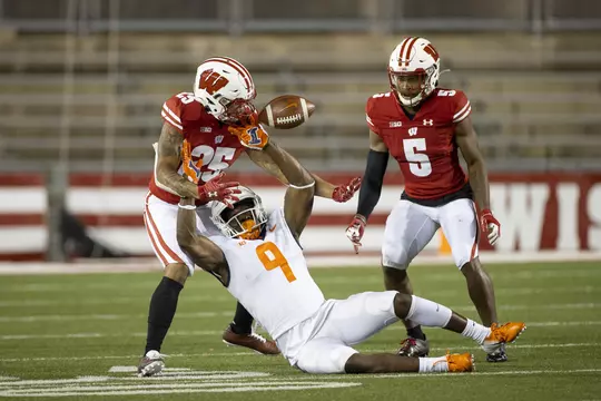 Wisconsin Badgers defensive backs Eric Burrell (25) and Rachad Wildgoose (5) break up a pass during an NCAA college football game against the Illinois Fighting Illini Friday, Oct. 23, 2020, in Madison, Wis. The Badgers won 45-7. (Photo by David Stluka/Wisconsin Athletic Communications)