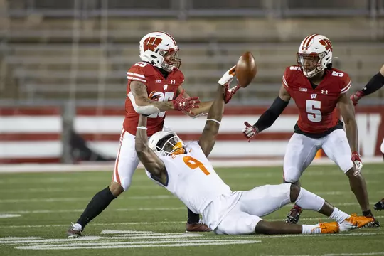 Wisconsin Badgers defensive backs Eric Burrell (25) and Rachad Wildgoose (5) break up a pass during an NCAA college football game against the Illinois Fighting Illini Friday, Oct. 23, 2020, in Madison, Wis. The Badgers won 45-7. (Photo by David Stluka/Wisconsin Athletic Communications)