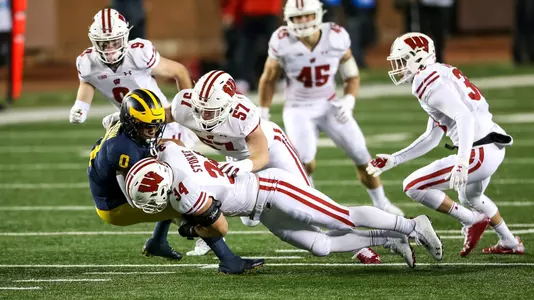Wisconsin Badgers' fullback Mason Stokke (34) and linebacker Jack Sanborn (57) combine on  tackle during an NCAA college football game against the Michigan Wolverines Saturday, Nov. 14, 2020, in Ann Arbor, Mich. The Badgers won 49-11. (Photo by Darren Lee/Wisconsin Athletic Communications)