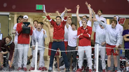 Men's swimmers cheer from the deck