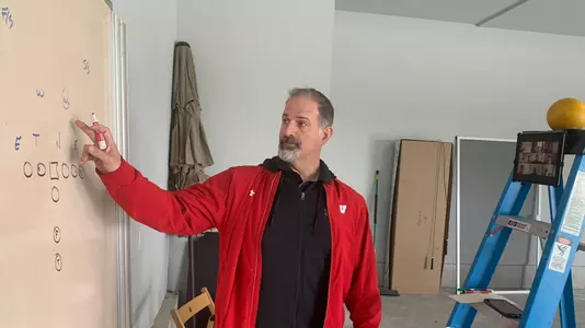 Wisconsin offensive coordinator Joe Rudolph coaches football student-athletes remotely from his home garage
