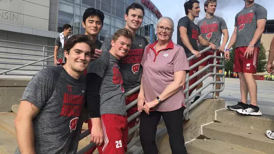 Academic advisor Mary Weaver-Klees on steps of Kohl Center with men's hockey team