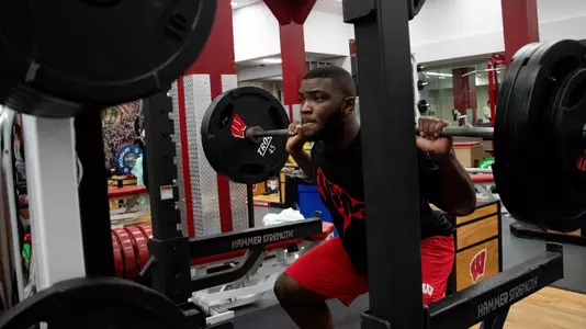 Football freshman student-athlete and linebacker Maema Njongmeta lifting weights