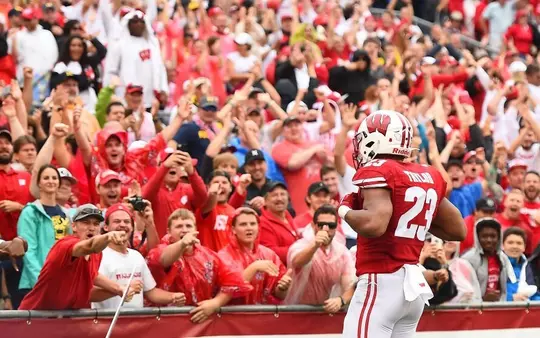 Jonathan Taylor football celebrating at touchdown with fans at Camp Randall Stadium