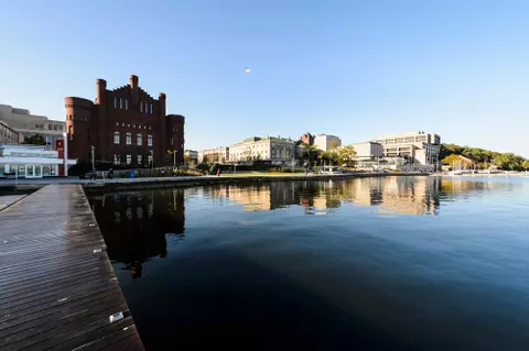 Pictured left to right from the Goodspeed Family Pier along the Lake Mendota shoreline is One Alumni Place, the Red Gym (Armory and Gymnasium), Alumni Park, Memorial Union Terrace and Helen C. White Hall at University of Wisconsin-Madison during the autumn morning of Oct. 8, 2017. The newly-opened Alumni Park is part of the Wisconsin Alumni Association (WAA). (Photo by Jeff Miller / UW-Madison)