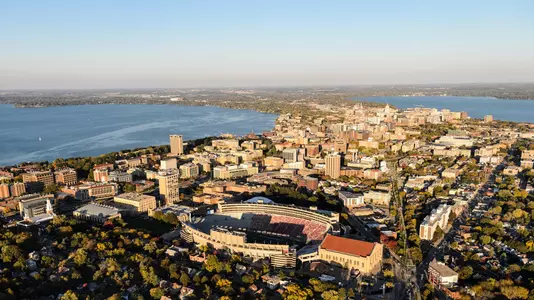 Aerial photo of The downtown Madison skyline and the University of Wisconsin-Madison campus, with Camp Randall Stadium in the foreground, along with Lake Mendota to the left and Lake Monona to the right are pictured in an aerial view during autumn on Oct. 13, 2016. The photograph was made from a helicopter looking east. (Photo by Jeff Miller/UW-Madison)