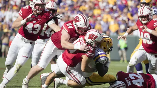 Wisconsin Badgers teammates T.J. Watt (42), Leo Musso (19) and Conor Sheahy (94) tackle LSU Tigers running back Leonard Fournette (7) during an NCAA college football game Saturday, September 3, 2016, in Green Bay, Wis. The Badgers beat the Tigers 16-14. (Photo by David Stluka)