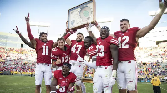 Wisconsin Badgers teammates celebrate with a trophy after an NCAA college football game against the LSU Tigers Saturday, September 3, 2016, in Green Bay, Wis. The Badgers beat the Tigers 16-14. (Photo by David Stluka)