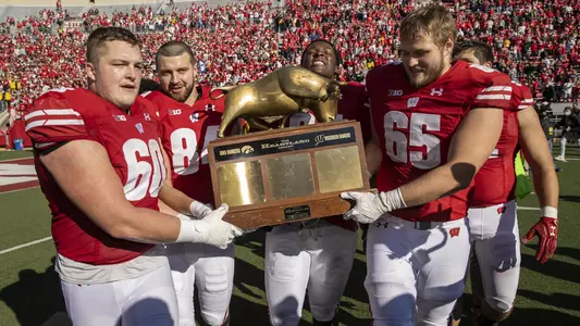 Wisconsin Badgers Logan Bruss (60), Jake Ferguson (84), Keeanu Benton (95) and Tyler Beach (65) carry the Heartland Trophy after an NCAA college football game against the Iowa Hawkeyes, Saturday, Oct. 30, 2021, in Madison, Wis. The Badgers won 27-7. (Photo by David Stluka/Wisconsin Athletic Communications)