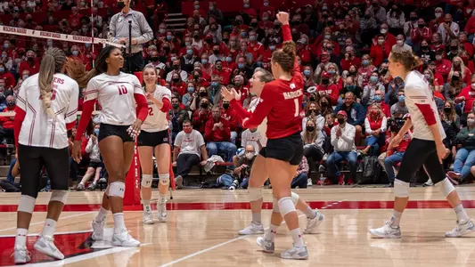 The Badgers celebrate a point against Penn State on the court.