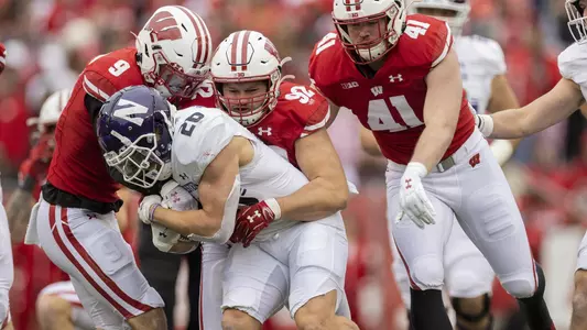 Wisconsin Badgers defenders Scott Nelson (9), Matt Henningsen (92) and Noah Burks (41) tackle Northwestern Wildcats running back Evan Hull (26) during an NCAA college football game, Saturday, Nov. 13, 2021, in Madison, Wis. The Badgers won 35-7. (Photo by David Stluka/Wisconsin Athletic Communications)