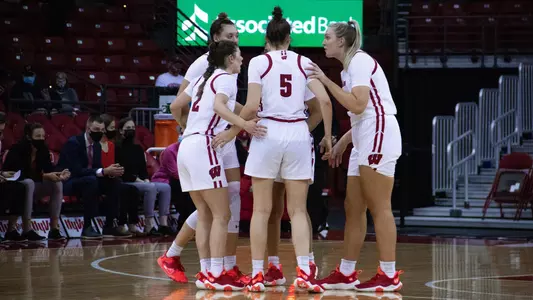 The Badger players huddle up on the court.