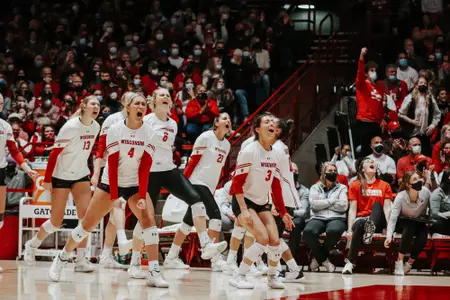 Volleyball team celebrates a point from the bench vs. Nebraska