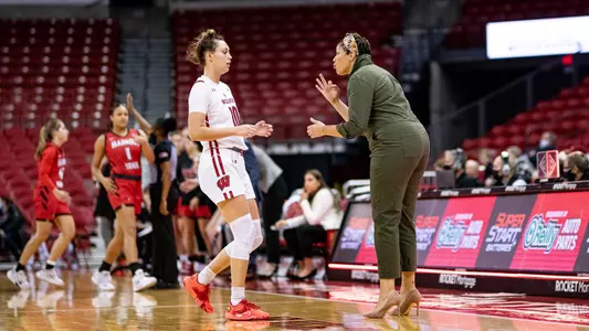 Head coach Marisa Moseley talks to Halle Douglass during a game.