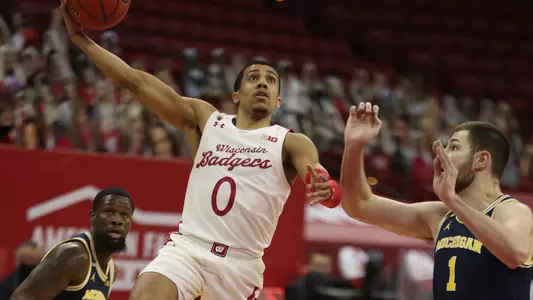 Feb 14, 2021; Madison, Wisconsin, USA; Wisconsin Badgers guard D'Mitrik Trice (0) shoots as Michigan Wolverines guard Franz Wagner (21) defends  during the first half at the Kohl Center. Mandatory Credit: Mary Langenfeld-USA TODAY Sports