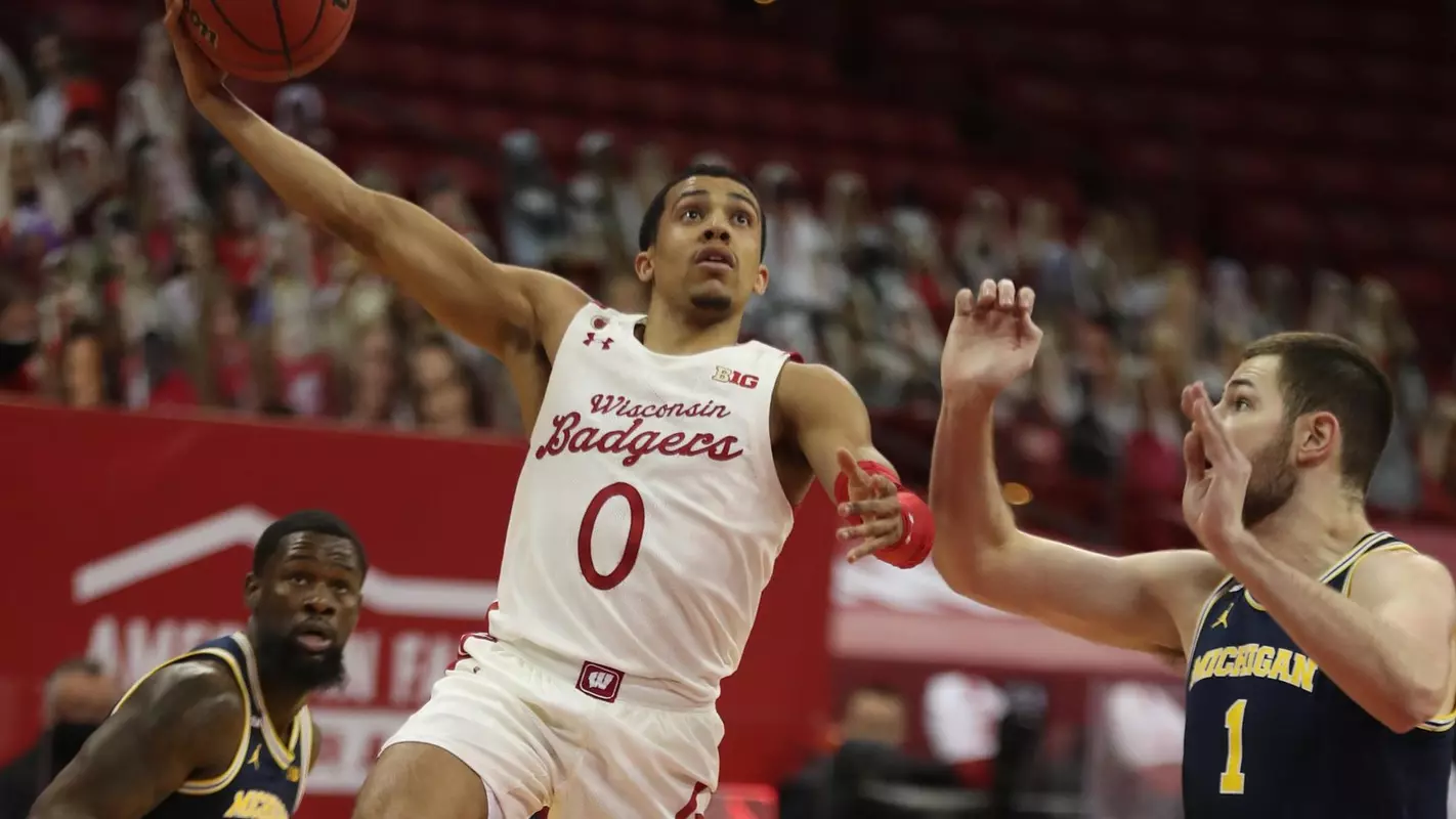 Feb 14, 2021; Madison, Wisconsin, USA; Wisconsin Badgers guard D'Mitrik Trice (0) shoots as Michigan Wolverines guard Franz Wagner (21) defends during the first half at the Kohl Center. Mandatory Credit: Mary Langenfeld-USA TODAY Sports