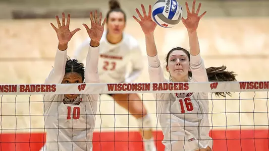 Devyn Robinson and Dana Rettke block a shot at the net.