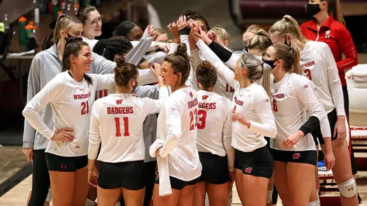 The Badgers huddle up before the start of a match on the sideline.